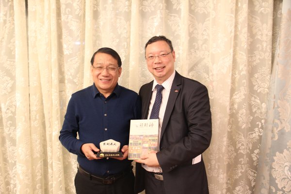 莫国栋（右）向张家口市人民政府副秘书长杜进明赠送李锦记“思利及人”石与《家族精神》
